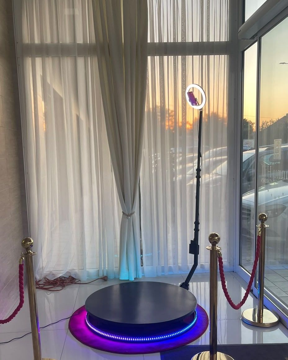 360 Glam Spin platforma sa ljubičastim LED osvetljenjem i prstenastim svetlom, okružena zlatnim stubićima sa crvenim užadima